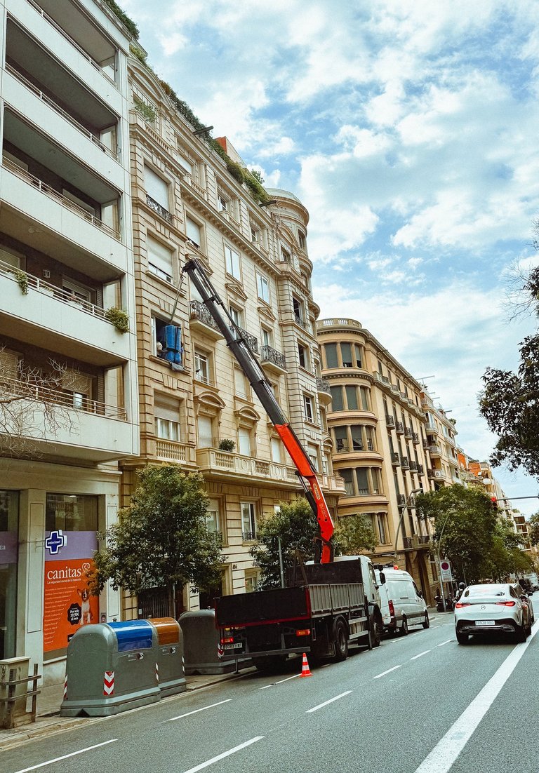 Grúa articulada elevando piano — especialistas en traslados difíciles Barcelona