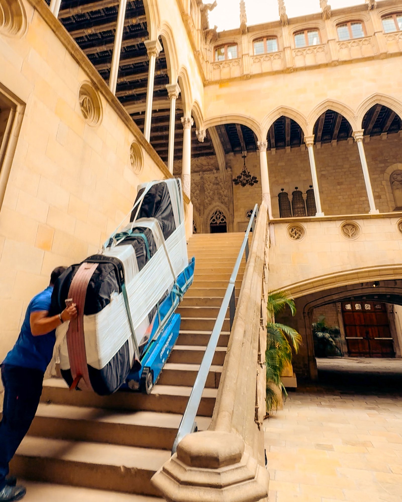 Técnico Pianos Port subiendo piano por escalera de edificio gótico en Barcelona